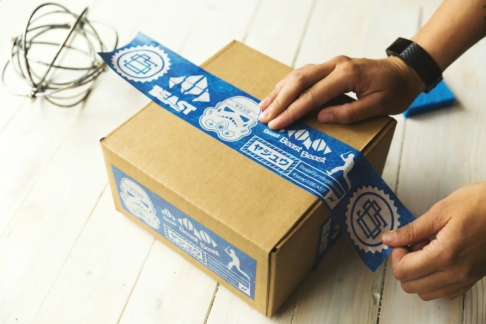 Hände verpacken einen Karton für die Rücksendung
